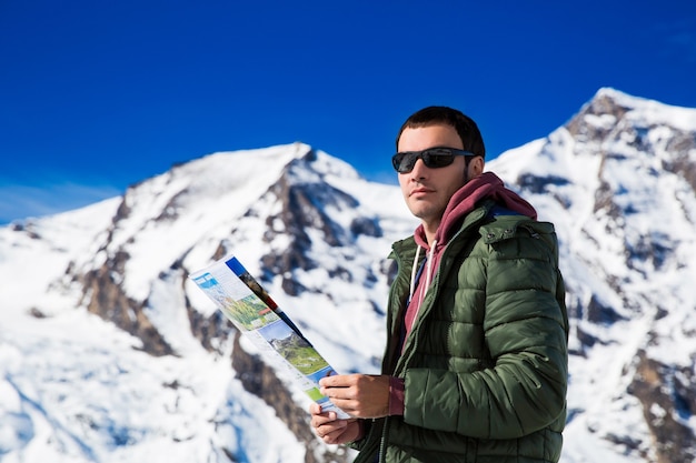 Man with a map looking forward to the background of snowy mountains. Grossglockner, Austria