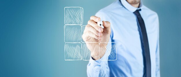 A man with a marker draws a ladder from cubes