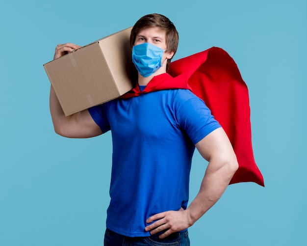 Man with mask holding box