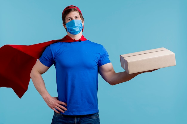 Man with medical mask holding box