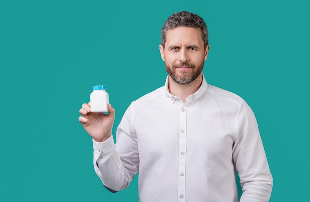 Man with medication isolated on blue background with copy space man hold medication