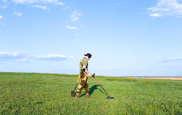 A man with a metal detector is looking for treasure Background for a treasure hunter Search for antiques with a metal detector