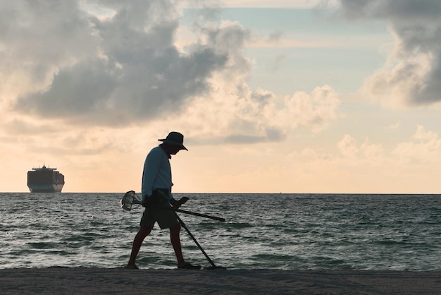 A man with metal detector at miami beach