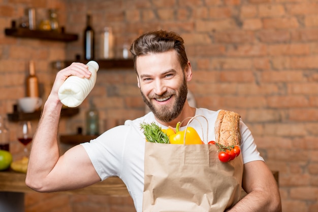 牛乳と食べ物がいっぱい入ったバッグを持つ男