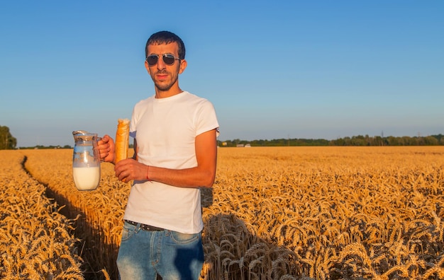 麦畑で牛乳とパンを持つ男 セレクティブ フォーカス