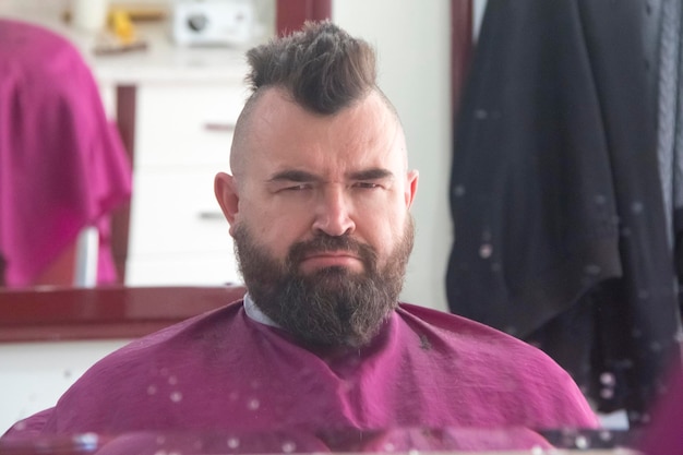 A man with a mohawk and beard in the barbershop