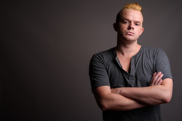 Photo man with mohawk hairstyle and blond hair against gray background