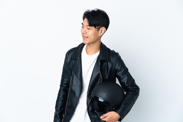 man with a motorcycle helmet posing isolated against the blank wall