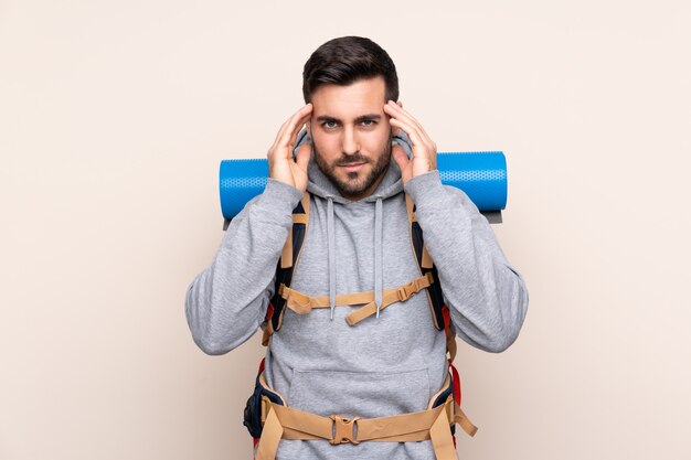 Man with mountaineer backpack over isolated wall