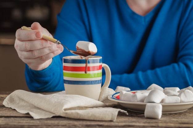 Man with mug hot cocoa with marshmallows, winter Christmas drink