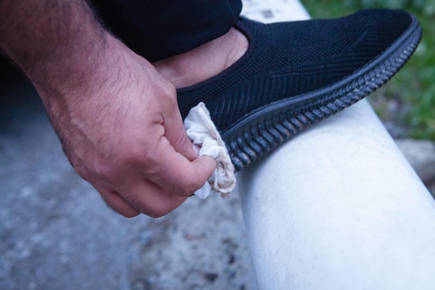 Man with a napkin to clean sneakers