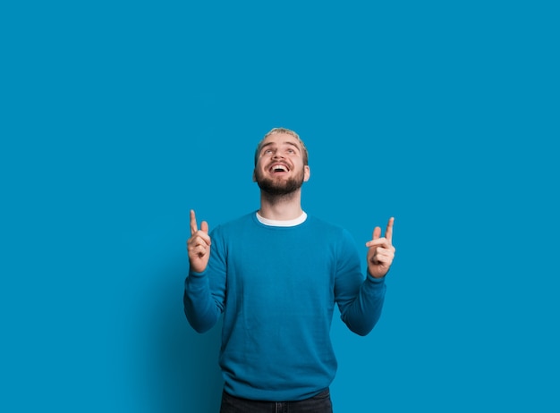 Photo man with nice beard is pointing and looking up