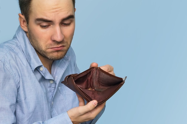 Photo man with no money. businessman holding empty wallet. man showing empty wallet by showing the inconsistency and lack of money and not able to pay the loan and the mortgage.