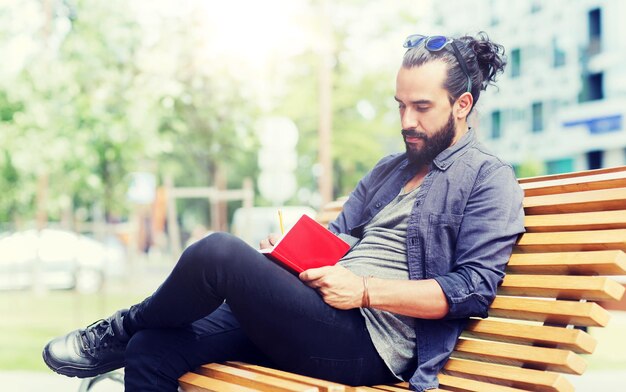 Man with notebook or diary writing on city street