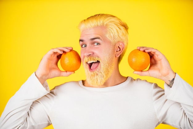 Man with the orange juice isolated on yellow.