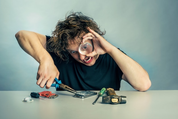 Foto uomo con espressione di panico sul viso a riparare un telefono