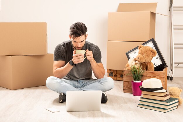 Man with pc and boxes moving to new home close up