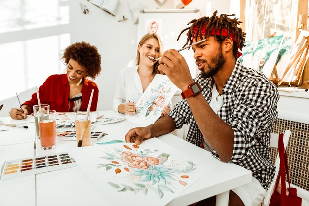 Man with pencil. Bearded man wearing red smart watch holding pencil while attending painting classes