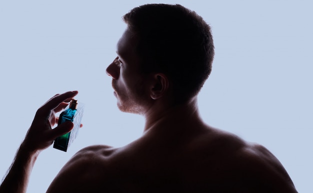 Man with perfume on light