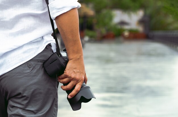 Uomo con la macchina fotografica della foto fashion travel lifestyle natura all'aperto sulla luce del sole