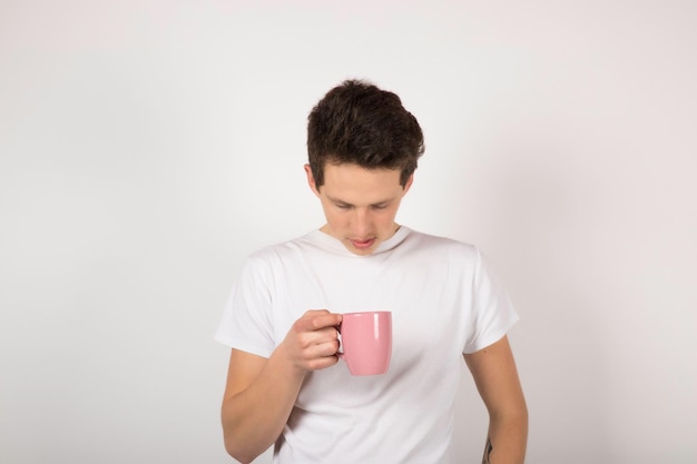 Мужчина с розовой чашкой на белом