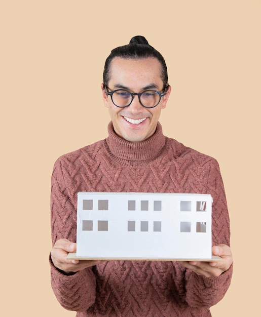 Foto uomo con coda di cavallo e occhiali in possesso di un modello di un concetto di architetto di casa