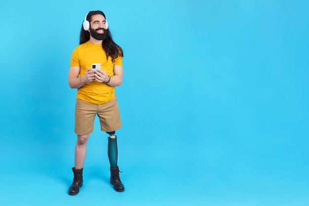 Man with prosthetic leg listening to music with the mobile