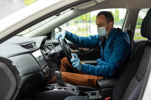 車を運転する保護マスクと手袋を持つ男。感染予防とエピデミックの制御。世界的大流行。おげんきで。