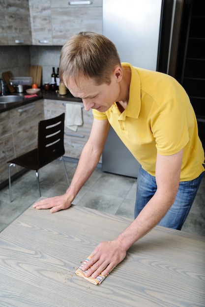 Man with rag wipes the crumbs from the table