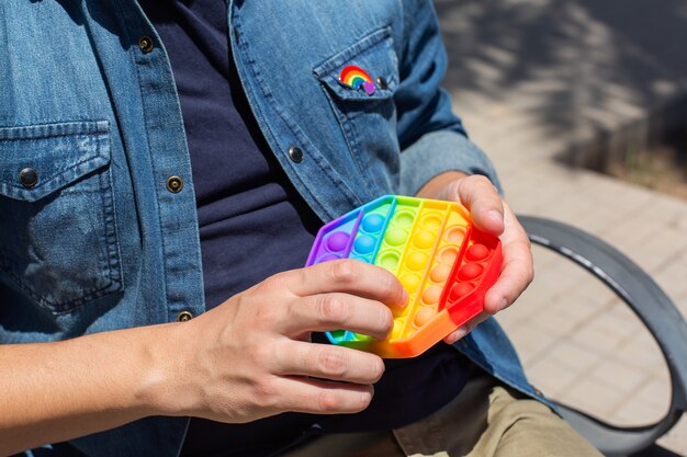 Uomo con arcobaleno pop it toy lgbt badge pride month