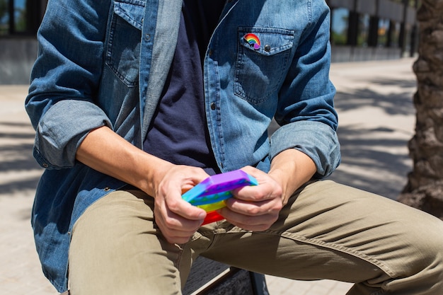 Uomo con arcobaleno pop it toy lgbt badge pride month