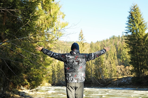 Man with raised arms enjoying the spruce forest