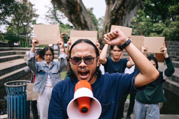 Man with raised fist shouting through megaphone human rights or justice with freedom of speech