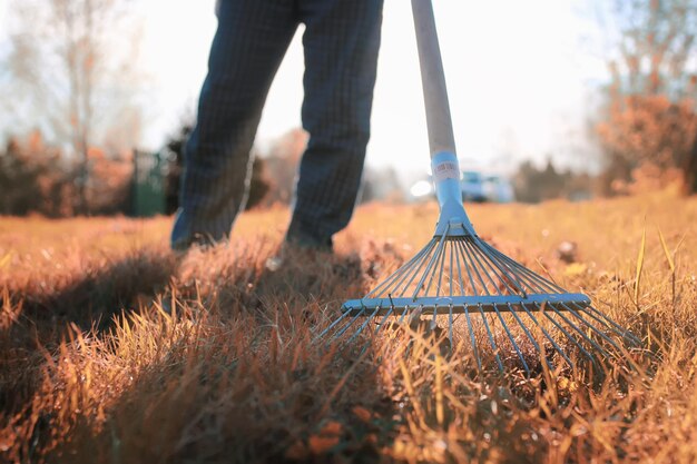 写真 秋の古い草の熊手を持つ男