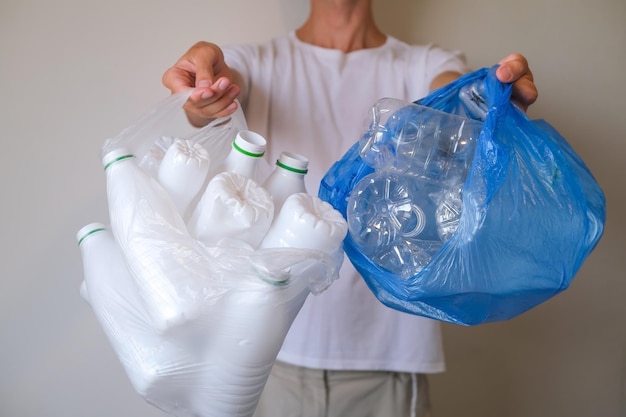 Man with recycling bags with plastic bottles, separate collection and recycling of waste