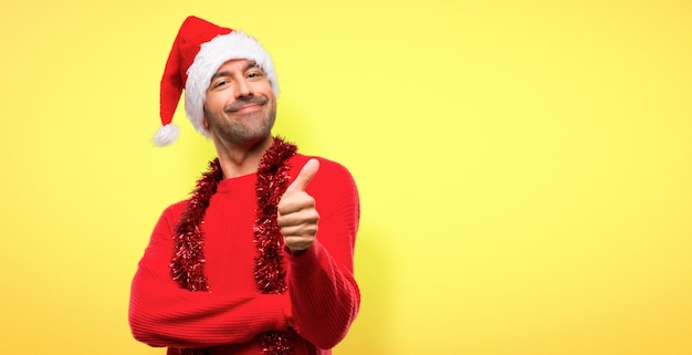 Man with red clothes celebrating the Christmas holidays giving a thumbs up gesture