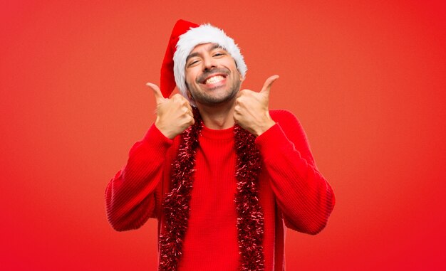 Man with red clothes celebrating the Christmas holidays giving a thumbs up