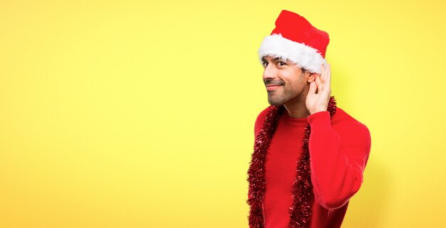 Uomo con abiti rossi che celebra le vacanze di natale ascoltando qualcosa