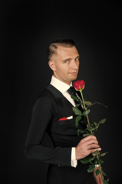 Man with red rose on dark background