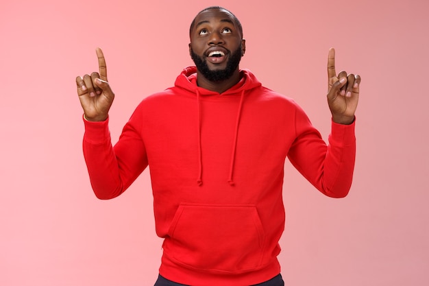 Man with a red sweatshirt over pink