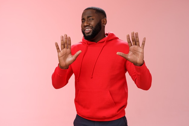 Man with a red sweatshirt over pink