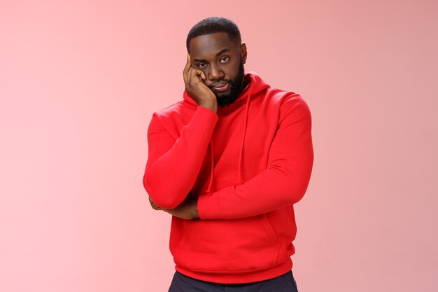 Man with a red sweatshirt over pink