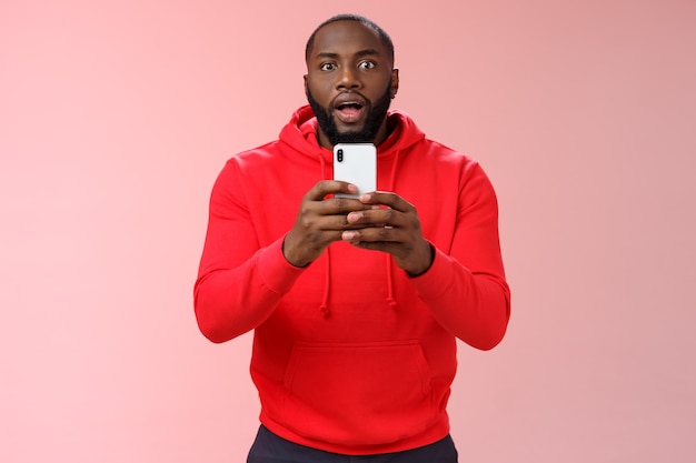 Man with a red sweatshirt over pink