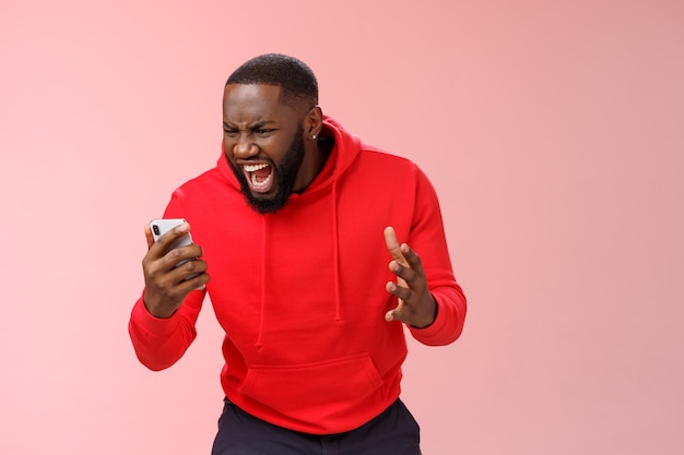 Man with a red sweatshirt over pink