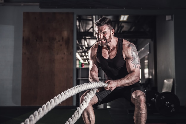 Man with rope in functional training gym