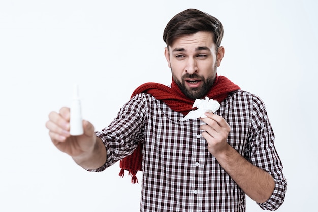 Photo man with a runny nose sneezes and shows nasal drops.