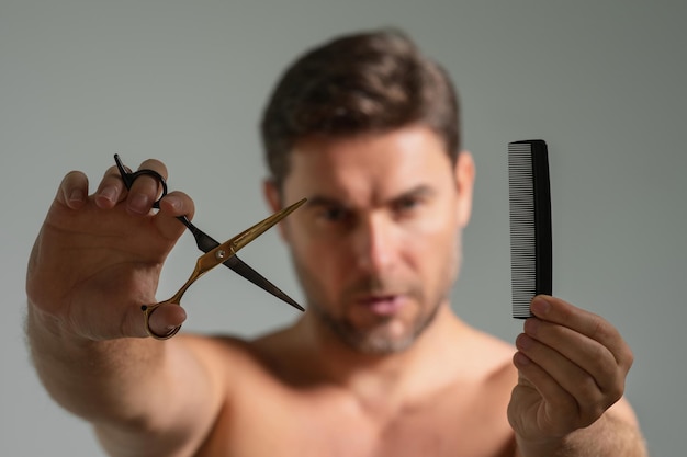 Man with scissors man cut hair with hairdressing scissors men haircut in studio barber scissors mens