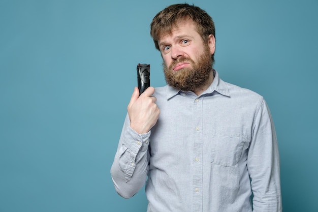 man with shaggy beard and hairstyle is annoyed that he has not been to the barbershop for long time