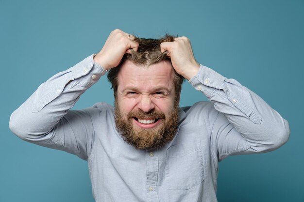 man with shaggy beard and hairstyle is annoyed that he has not been to the barbershop for long time