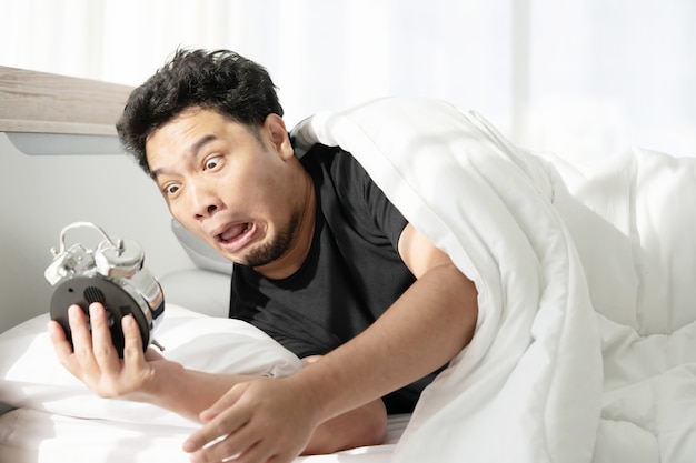 Photo a man with shocked face after wakeing up late